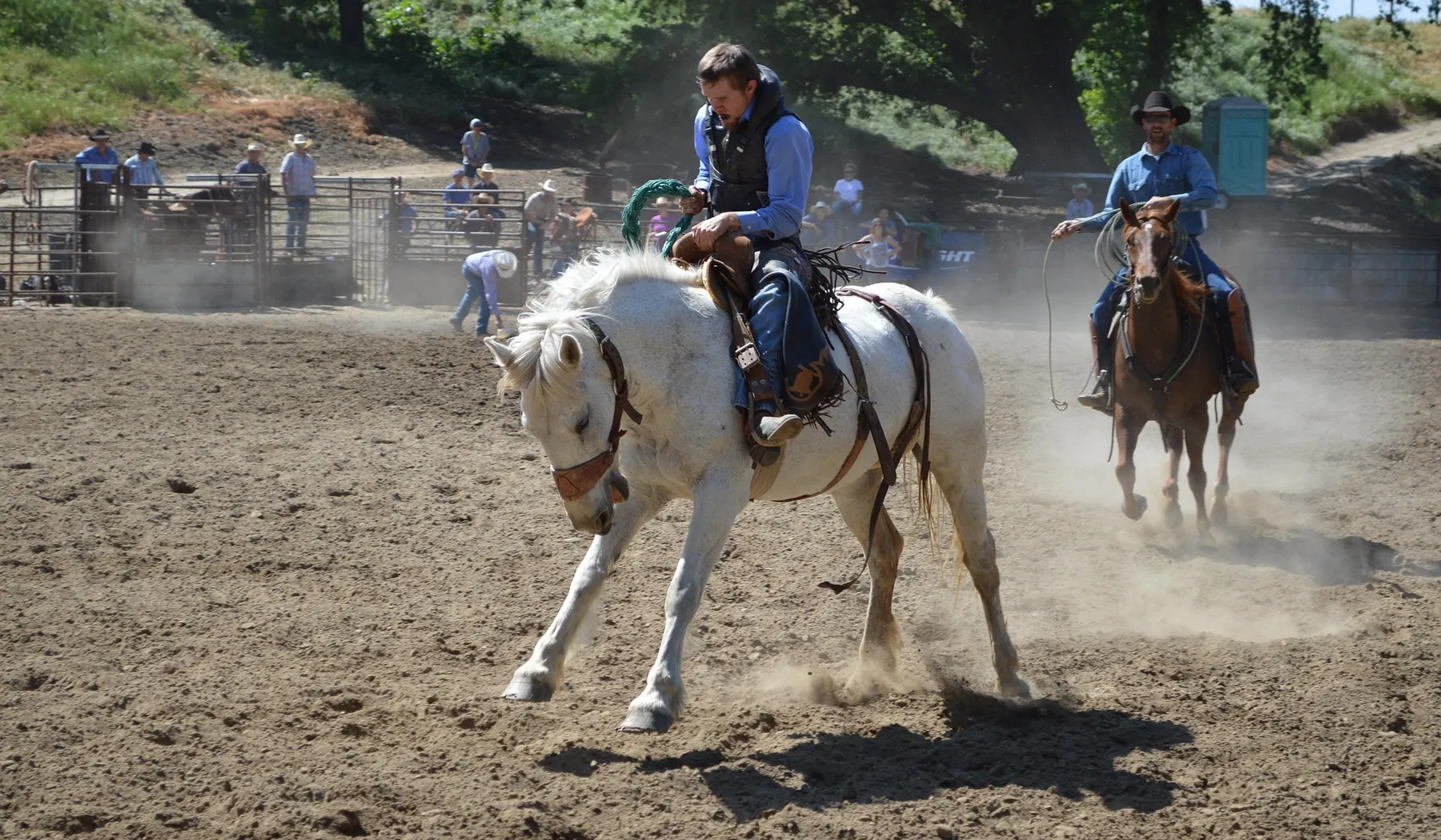 Barrel racers competing in a dusty arena